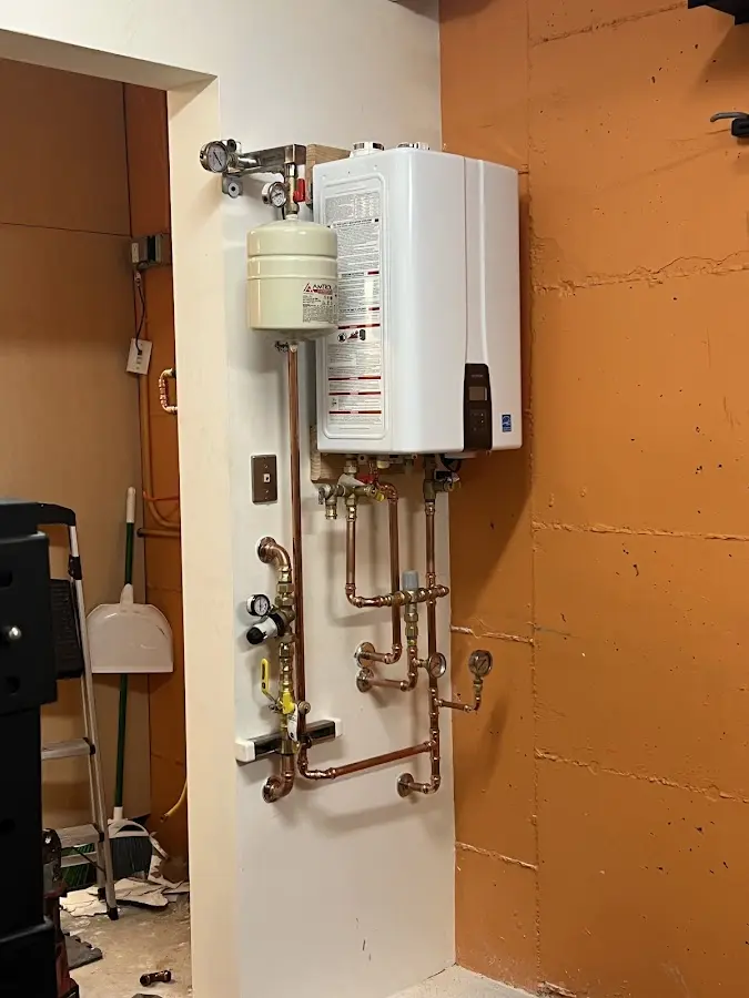 Plumbing technician inspecting water heater connections in University of Virginia